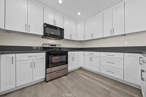 a kitchen with white cabinets and stainless steel appliances