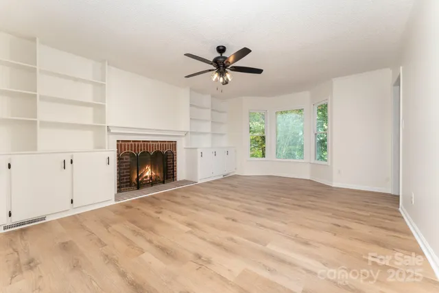 a view of an empty room with a fireplace and a window