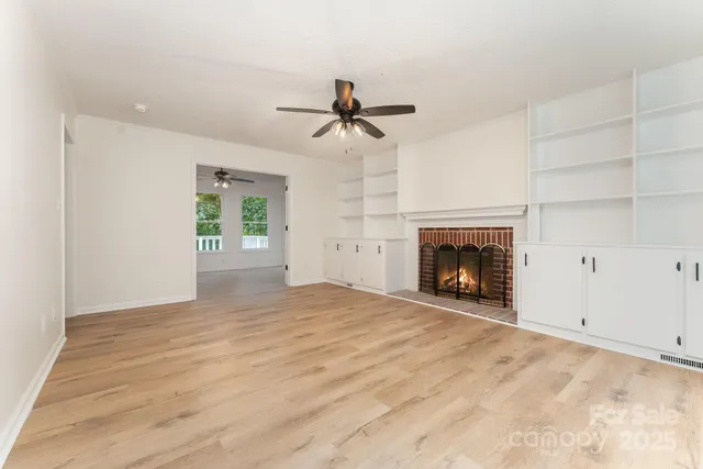 a view of empty room with fireplace and fan