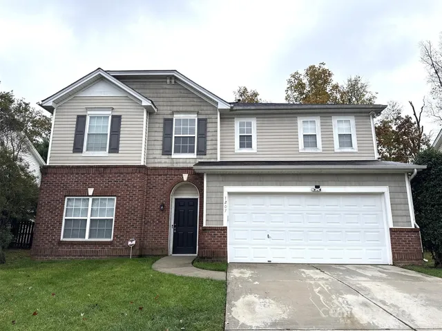 a front view of a house with a garden and yard
