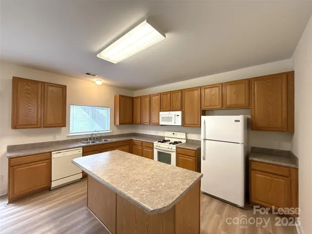 a kitchen with a refrigerator a stove top oven and a center island
