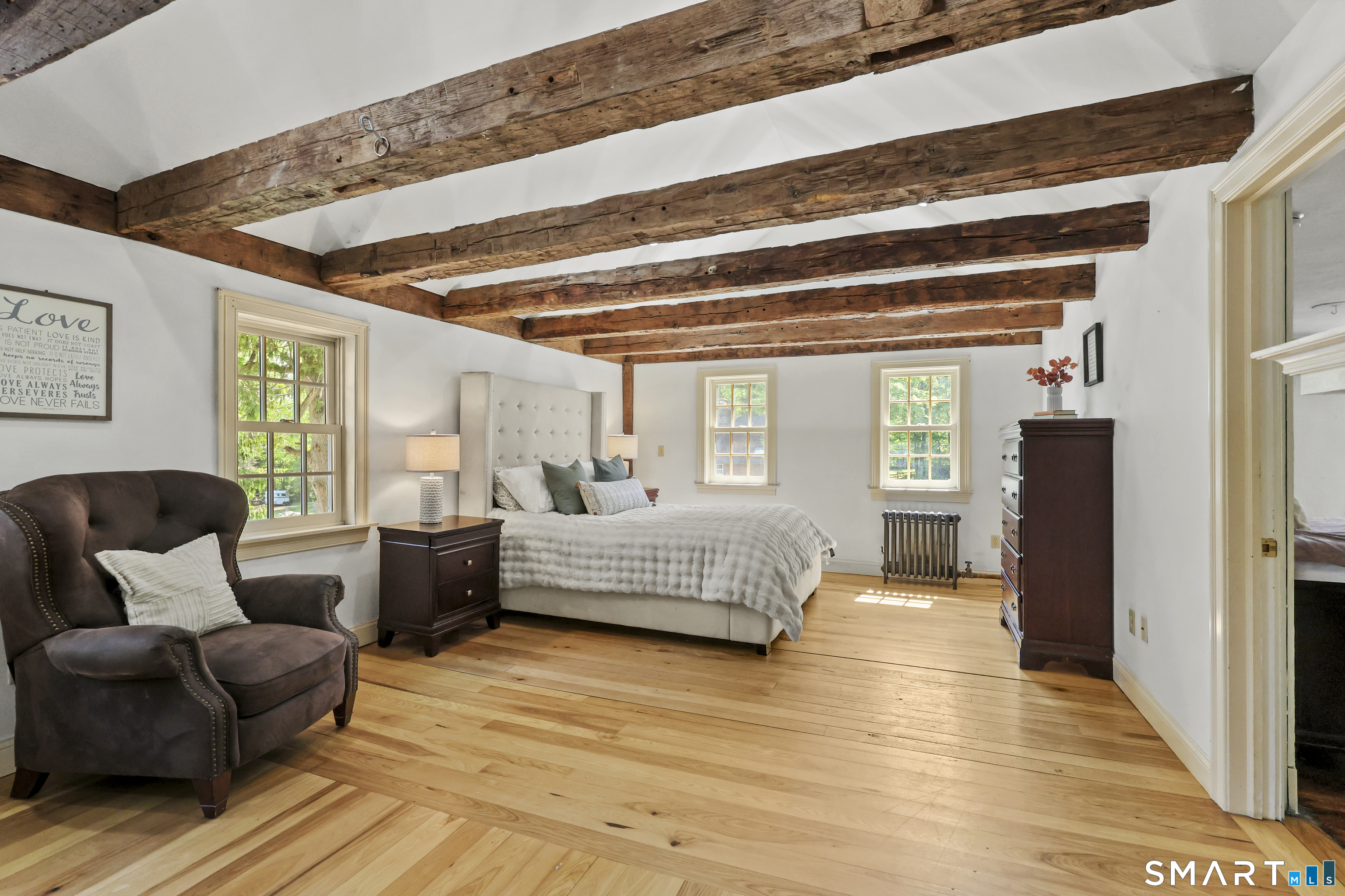 2880 Main Street Coventry, CT 06238 - Photo 22 of 40 Serene primary bedroom retreat with French doors, vaulted ceiling, exposed beams, and hardwood floors.