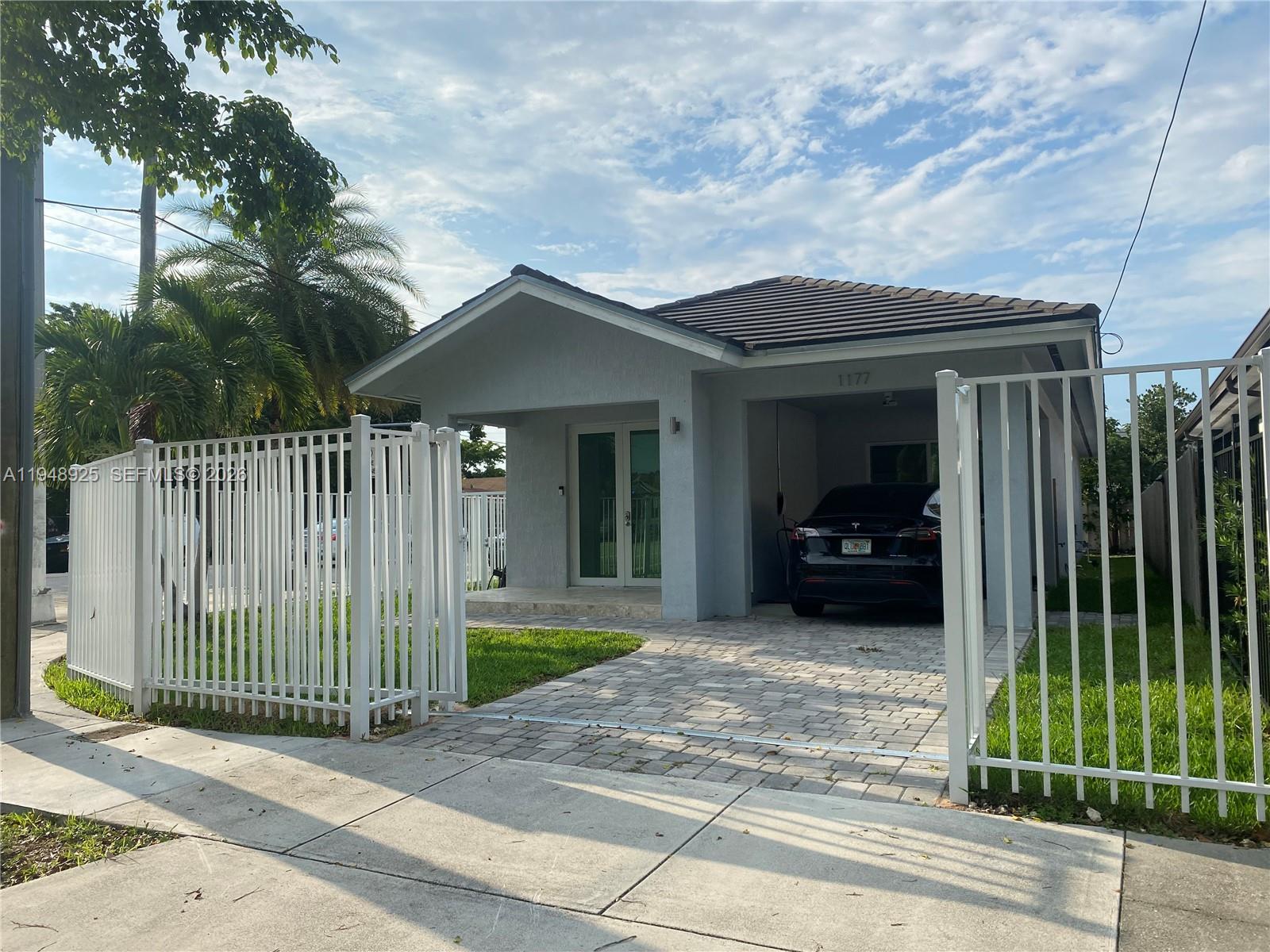 a view of a house with a small yard and wooden fence