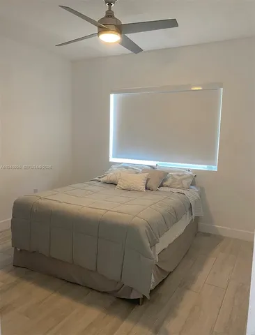 a bedroom with a bed and a ceiling fan