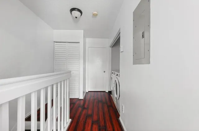 a view of a hallway with wooden floor and staircase