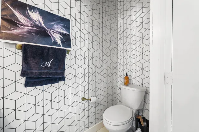 a white toilet sitting next to a white wall