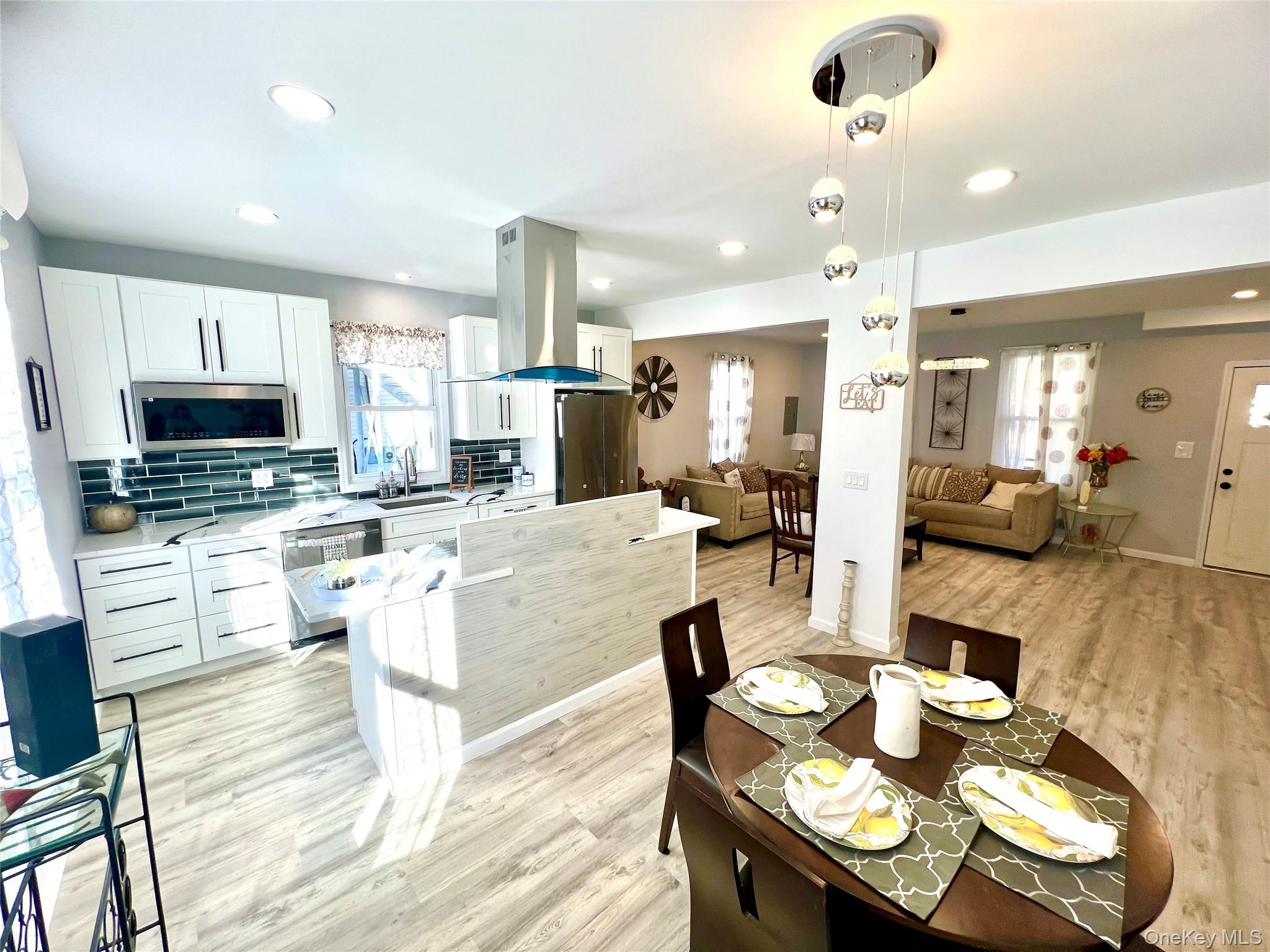 126 West Main Street, Unit 1 Middletown, NY 10940 - Photo 8 of 29 a large kitchen with kitchen island granite countertop a stove a sink a dining table and chairs