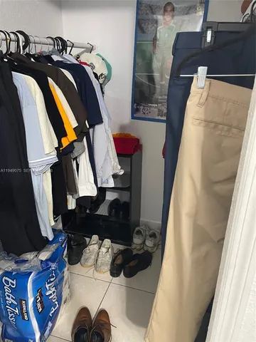 a view of walk in closet with clothes and shoes