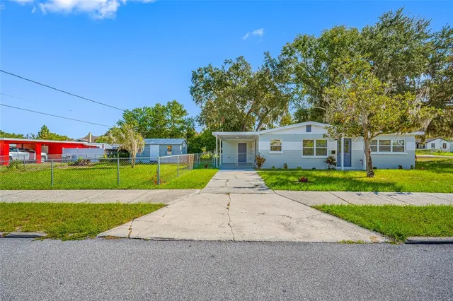 a view of a house with a yard and a street