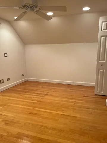 an empty room with wooden floor and entrance