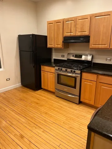 a kitchen with stainless steel appliances granite countertop a refrigerator stove and sink