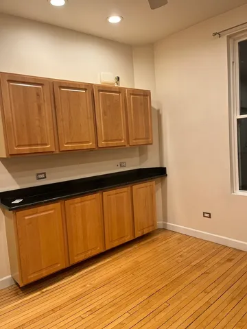 a view of kitchen with wooden floor and cabinets