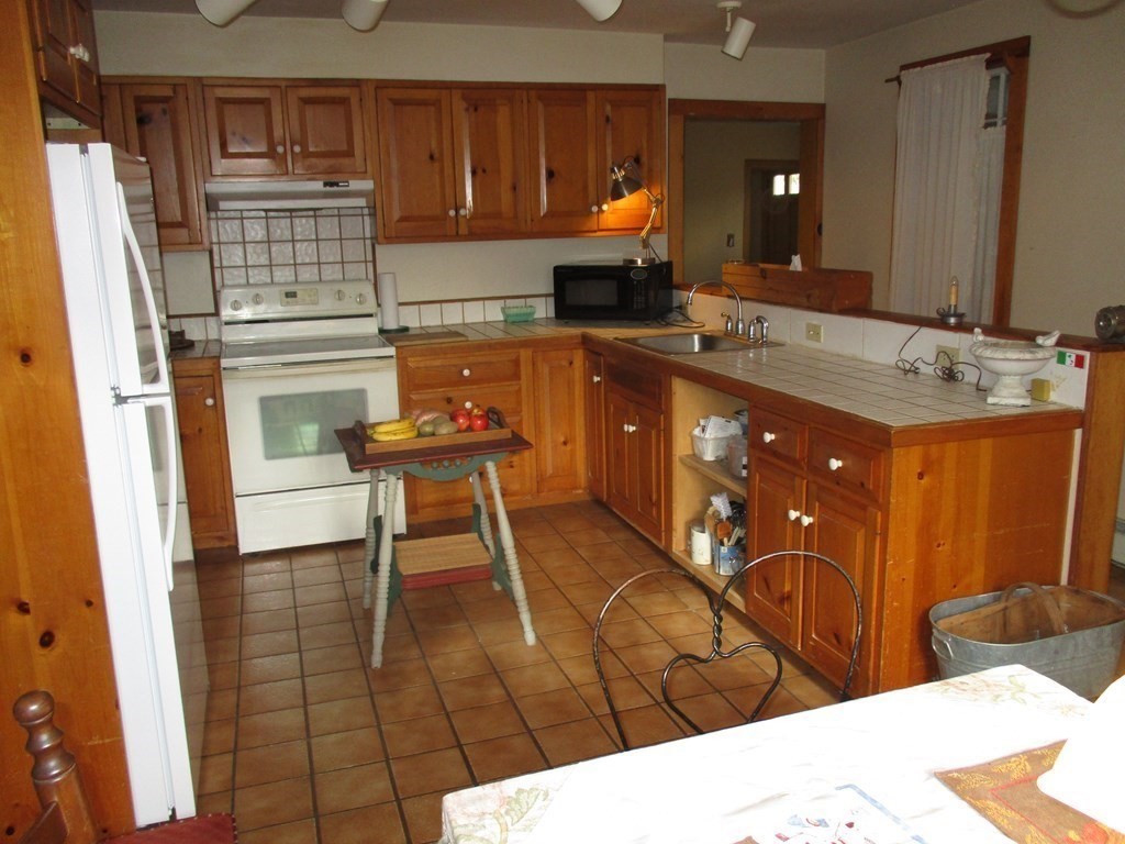 258 Chestnut Street Rehoboth, MA 02769 - Photo 6 of 34 a kitchen with stainless steel appliances kitchen island granite countertop a refrigerator and a stove top oven