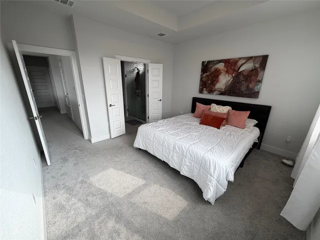 a bedroom with a bed and a painting on the wall