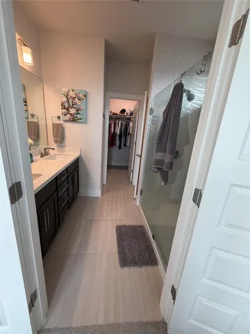a walk in closet with view of bathroom