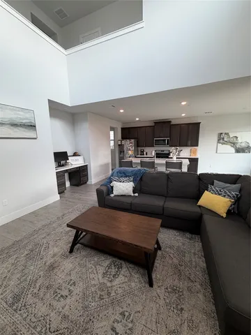 a living room with furniture and kitchen