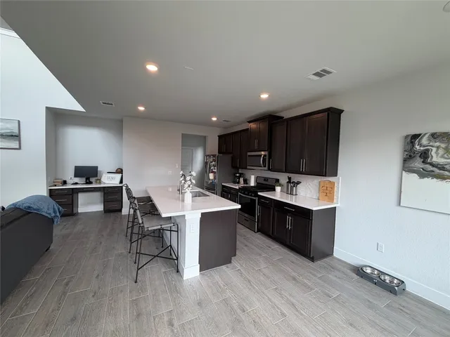 a kitchen with a sink cabinets and wooden floor