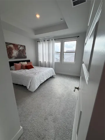 a bedroom with a bed toilet and window