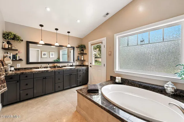 a view of a house with a big yard potted plants and large tree