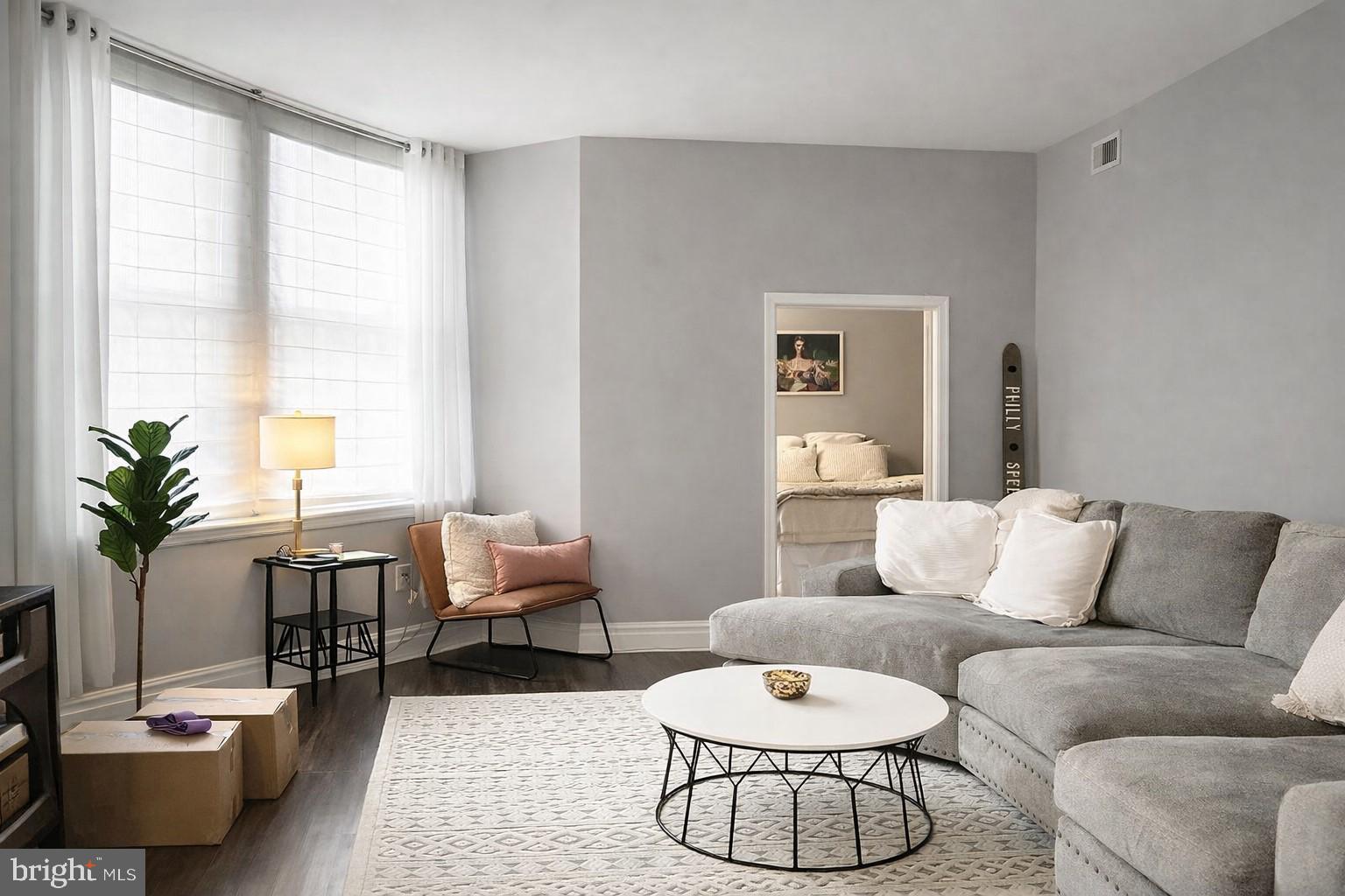 a living room with furniture potted plant and a large window