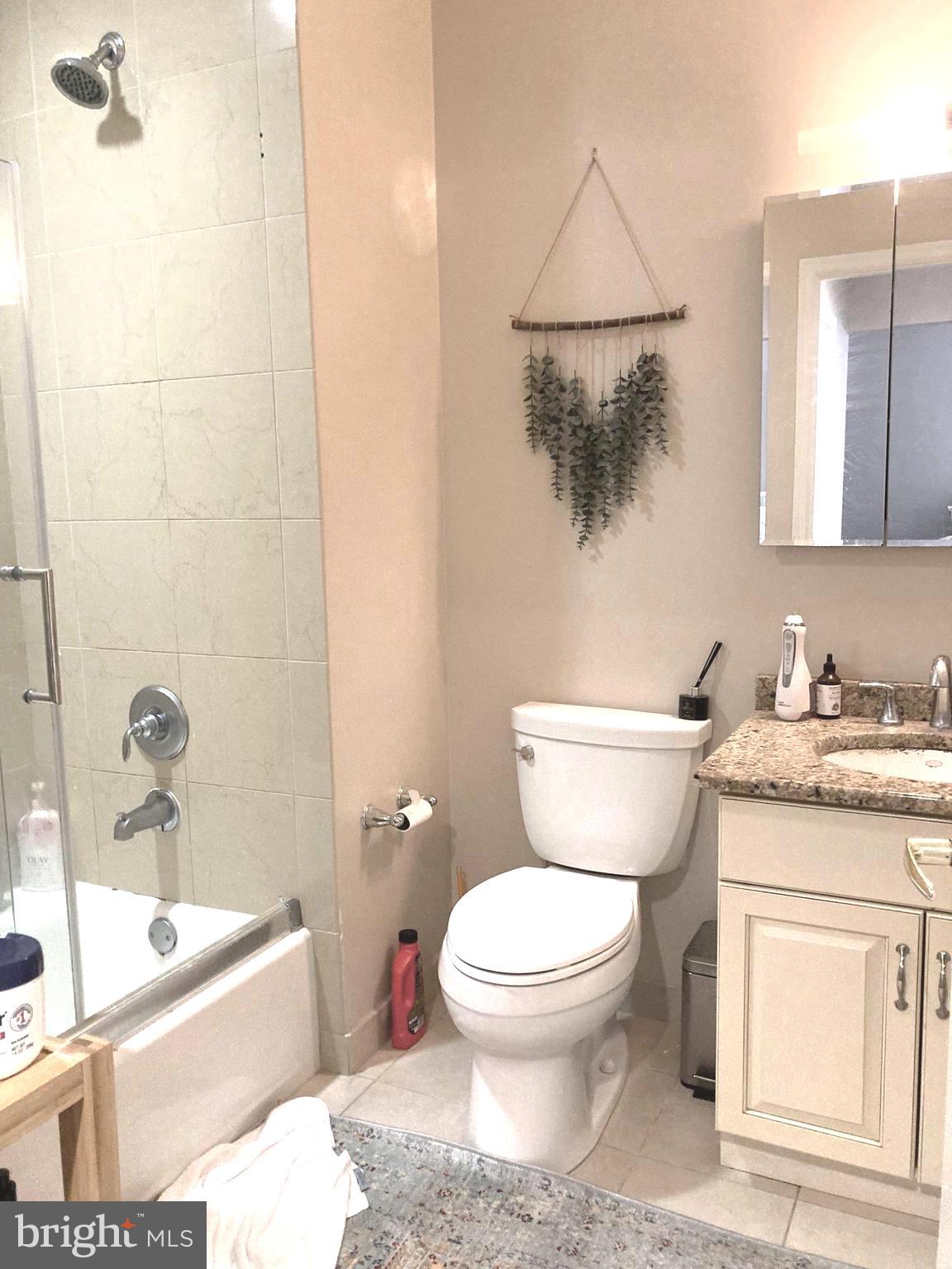 1600-18 Arch Street, Unit 1013 Philadelphia, PA 19103 - Photo 11 of 31 a bathroom with a granite countertop toilet a sink and bathtub