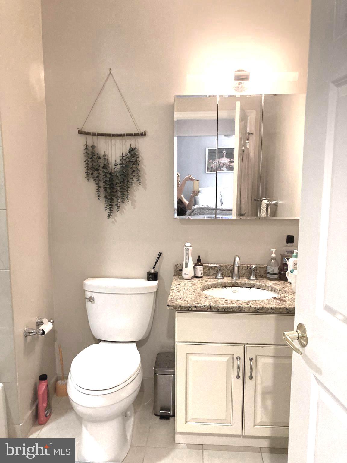 1600-18 Arch Street, Unit 1013 Philadelphia, PA 19103 - Photo 12 of 31 a bathroom with a toilet a sink and mirror