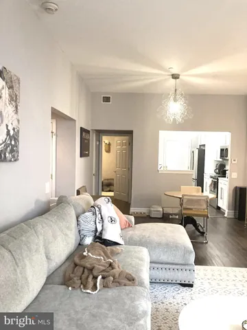 a bedroom with a bed couch and wooden floor