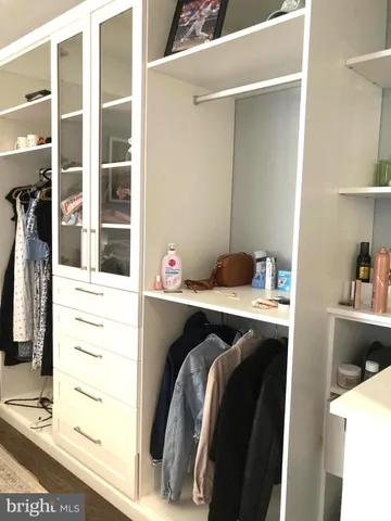 a view of walk in closet with clothes and shoes