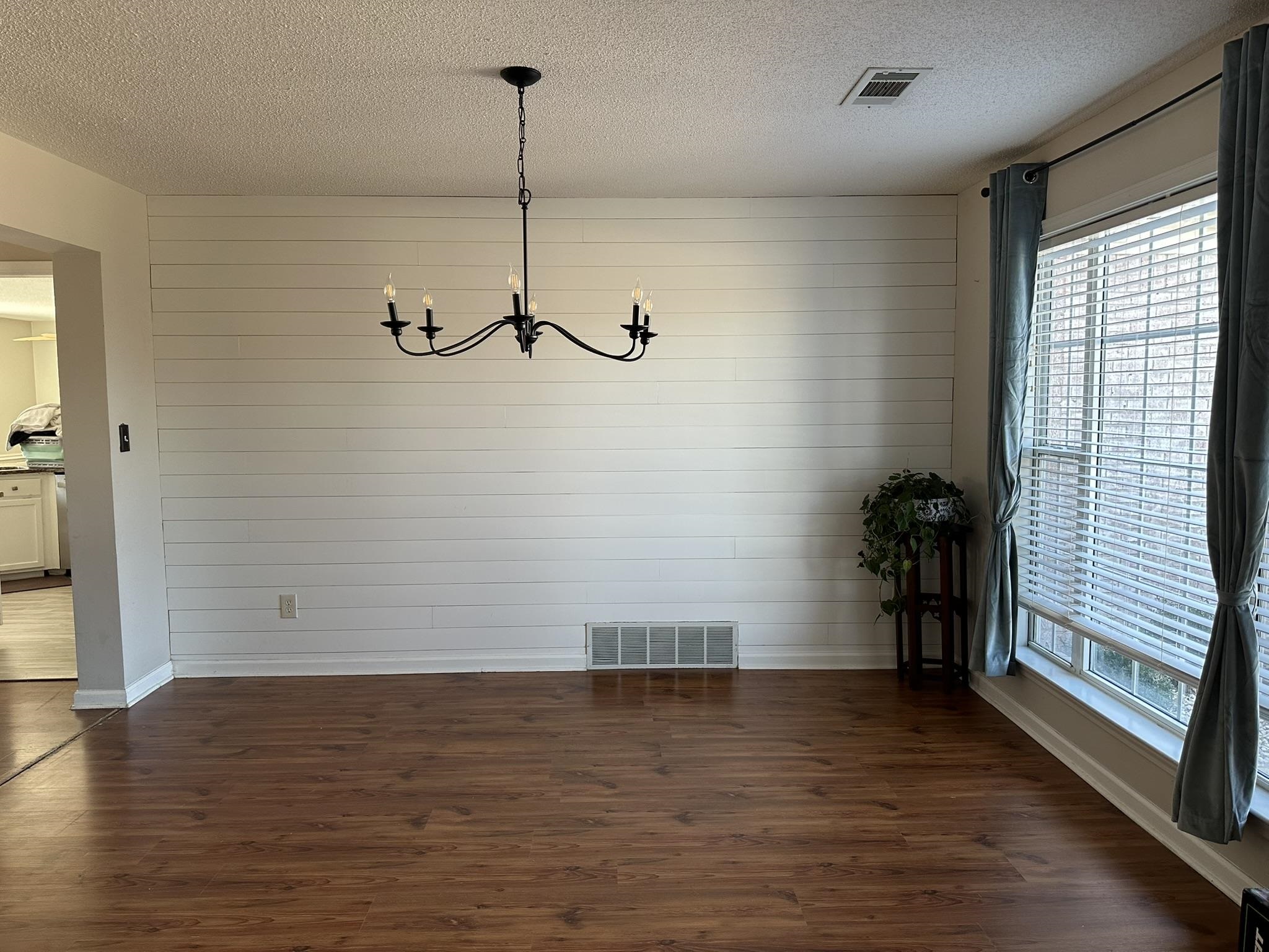 25 Whispering Ridge Cove Oakland, TN 38060 - Photo 8 of 20 Unfurnished dining area with a notable chandelier, dark wood-type flooring, and a textured ceiling