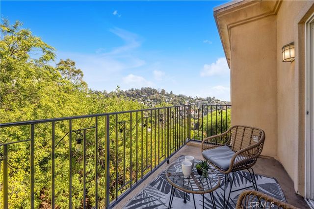 a roof deck with table and chairs and potted plants with wooden floor