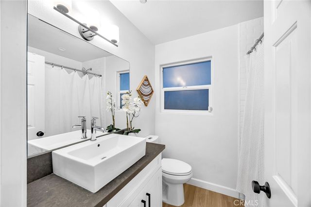 a bathroom with a sink toilet a mirror a vanity and shower