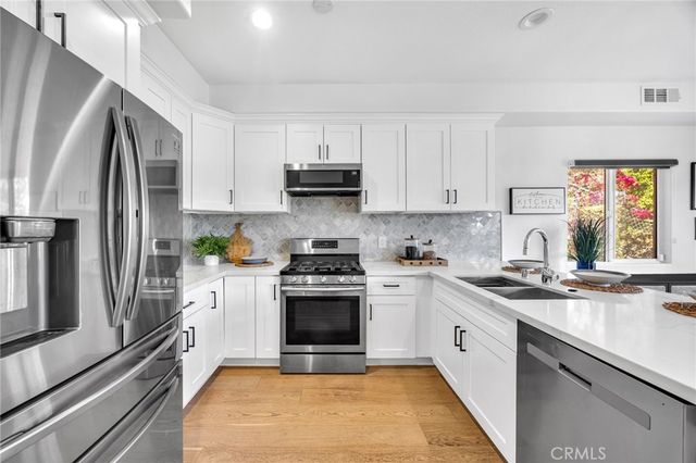a kitchen with stainless steel appliances granite countertop a stove a sink and a refrigerator