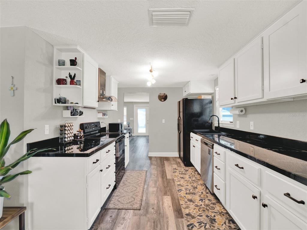 2721 Evergreen Drive Edgewater, FL 32141 - Photo 6 of 29 a kitchen with granite countertop a sink stove and refrigerator
