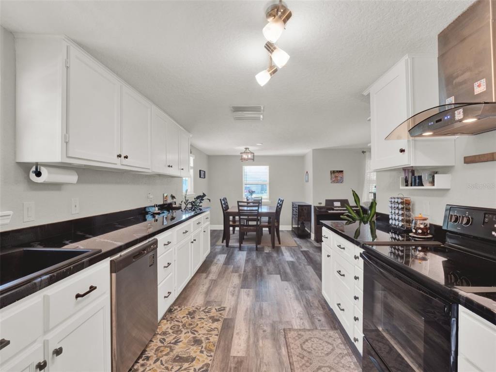 2721 Evergreen Drive Edgewater, FL 32141 - Photo 8 of 29 a kitchen with granite countertop lots of counter top space a sink stainless steel appliances and cabinets