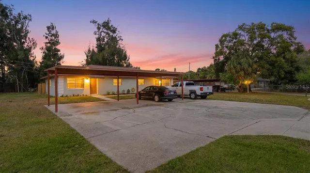 a front view of a house with a garden and tree