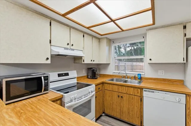 a kitchen with stainless steel appliances granite countertop a sink stove and cabinets