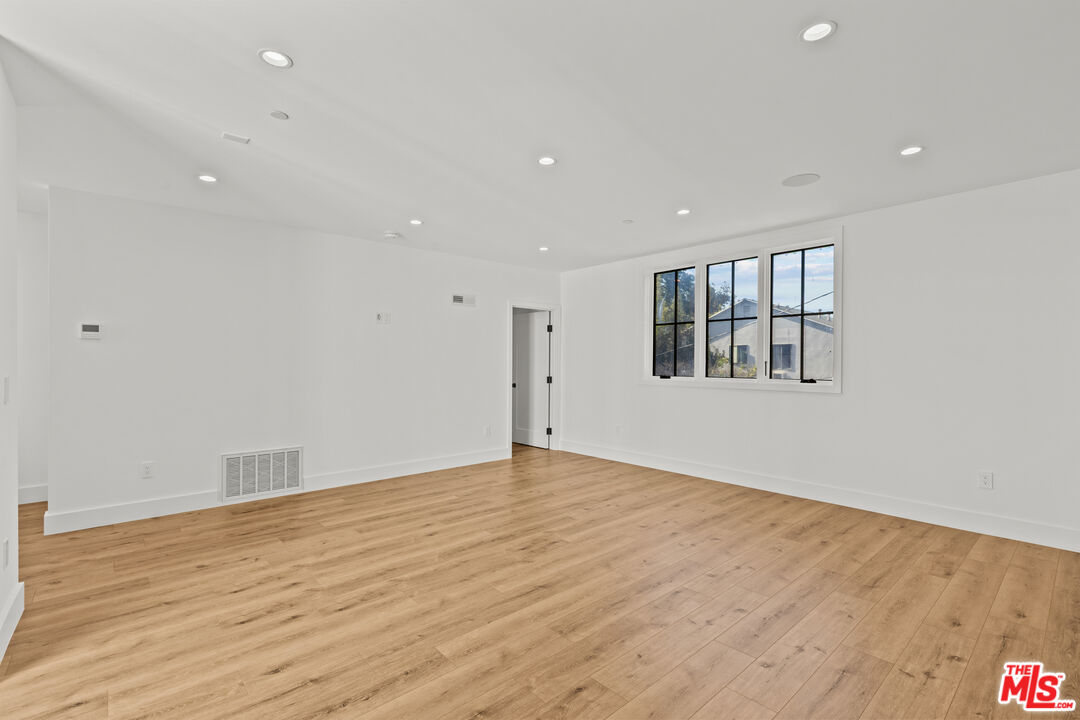 5539 Tova Road Sherman Oaks, CA 91411 - Photo 11 of 17 a view of empty room with wooden floor and fan