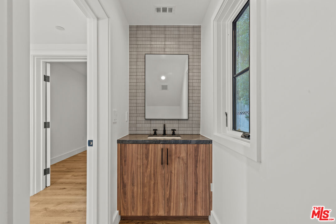 5539 Tova Road Sherman Oaks, CA 91411 - Photo 12 of 17 a bathroom with a granite countertop sink and a mirror