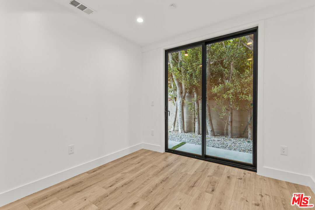 5539 Tova Road Sherman Oaks, CA 91411 - Photo 13 of 17 a view of an empty room with wooden floor and a window