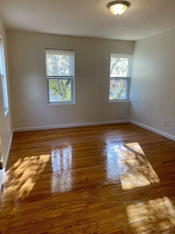 123 Thorndike Street, Unit 2L Cambridge, MA 02141 - Photo 12 of 19 an empty room with wooden floor and windows
