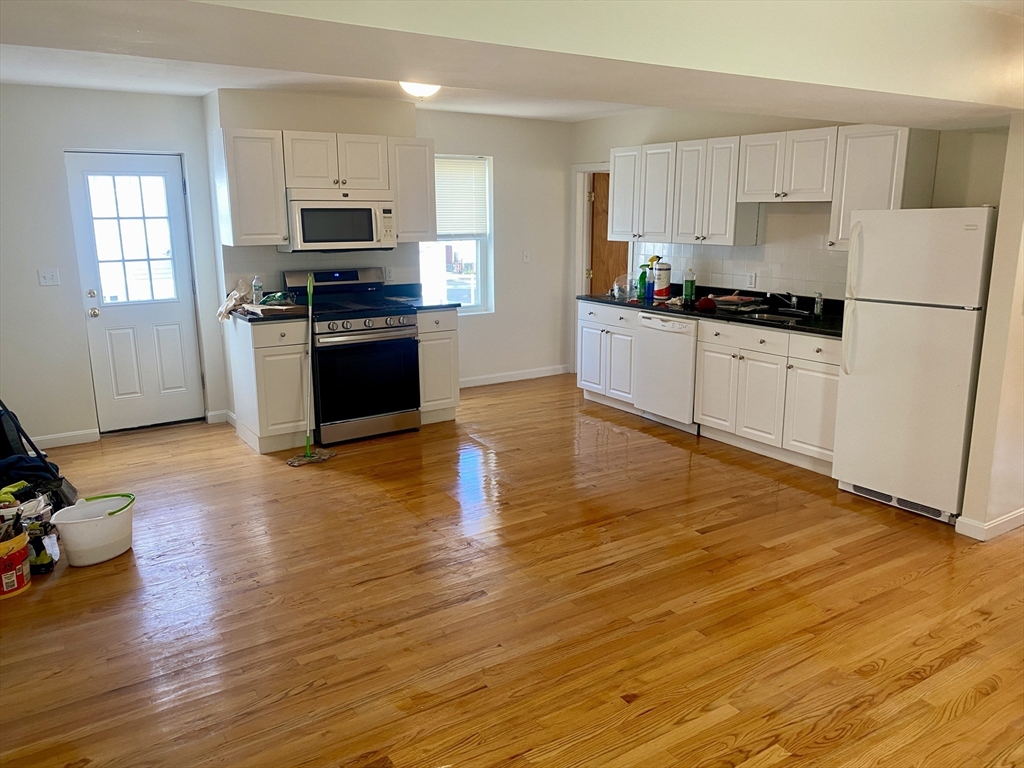 123 Thorndike Street, Unit 2L Cambridge, MA 02141 - Photo 2 of 19 a kitchen with granite countertop a refrigerator and a stove top oven