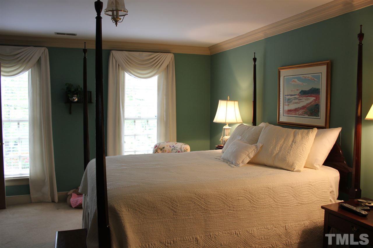 3308 Churchill Road Raleigh, NC 27607 - Photo 16 of 25 a bedroom with a bed and a painting on the wall