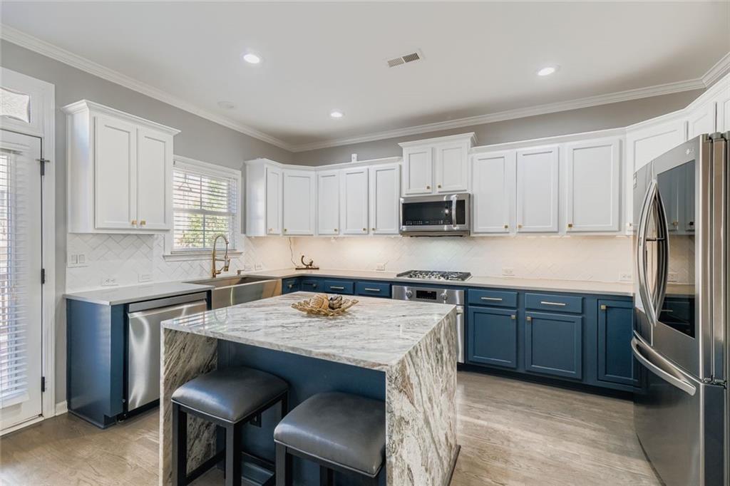 6414 Queens Court Trace, Unit 7 Mableton, GA 30126 - Photo 13 of 28 a kitchen with kitchen island granite countertop a sink counter and chairs