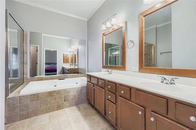 a spacious bathroom with a tub sink and mirror