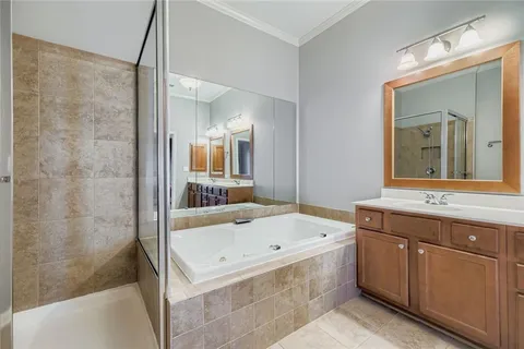 a bathroom with a tub a sink and mirror