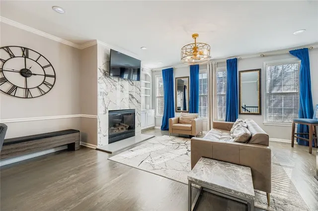 a living room with furniture a fireplace and a large window