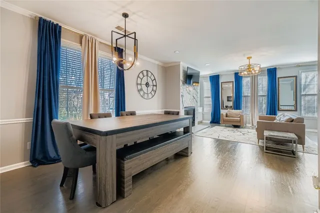 a living room with furniture a large window and wooden floor