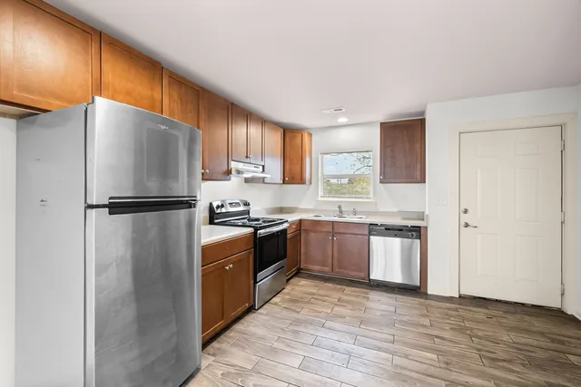 a kitchen with granite countertop stainless steel appliances a refrigerator and a sink
