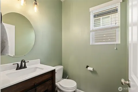 a bathroom with a sink vanity mirror and toilet