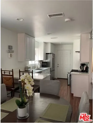 a kitchen with stainless steel appliances kitchen island granite countertop a refrigerator and a stove
